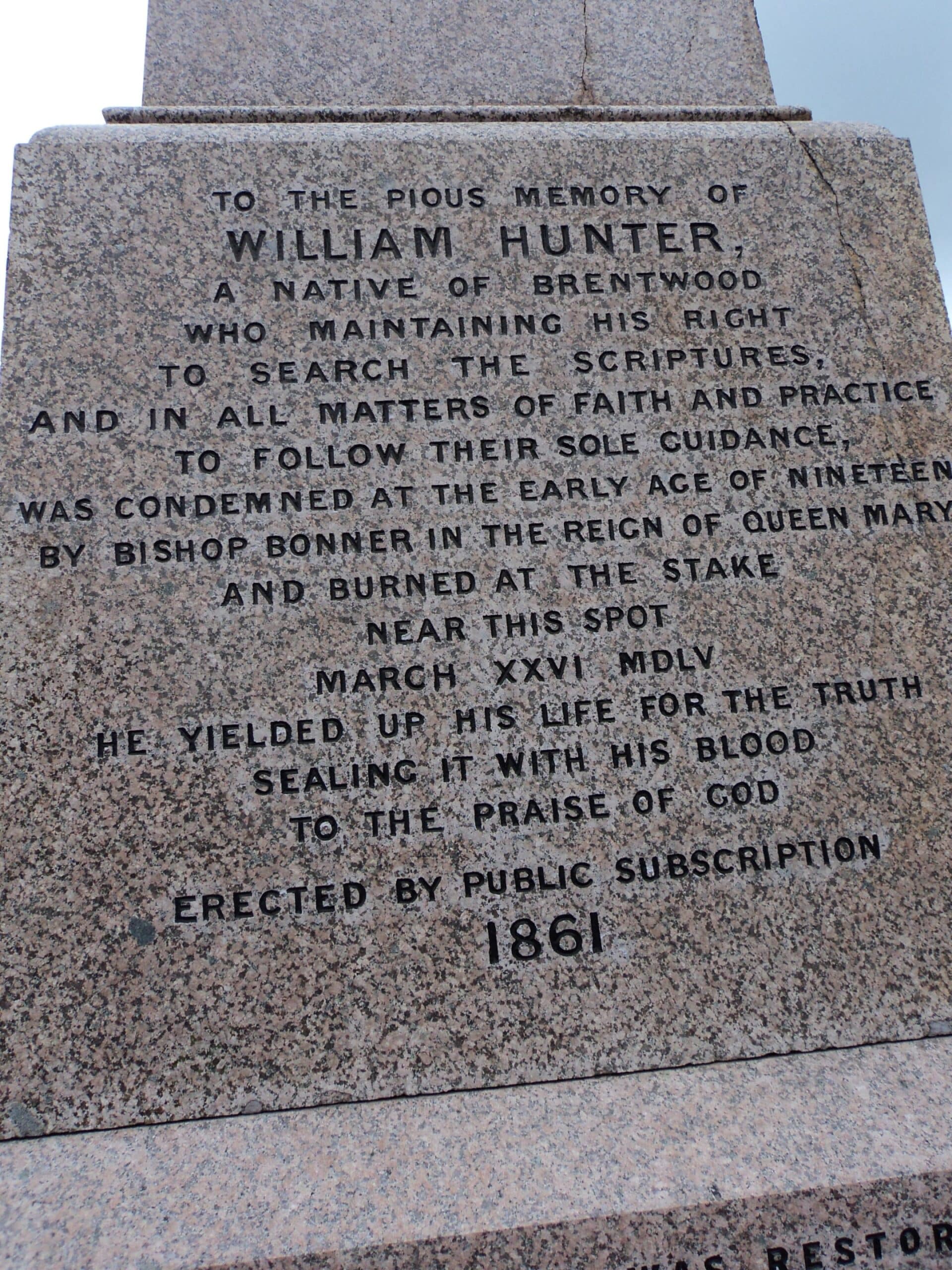 Inscription on a stone monument commemorating William Hunter, who was burnt at the stake in 1555 for his faith. The text honours his sacrifice and notes the monument was erected by public subscription in 1861.