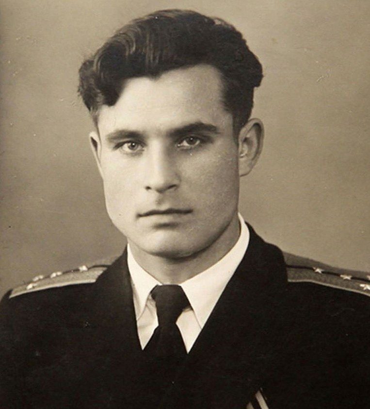 Black-and-white portrait of a young man with dark, wavy hair wearing a military uniform with epaulettes, looking directly at the camera with a neutral expression.