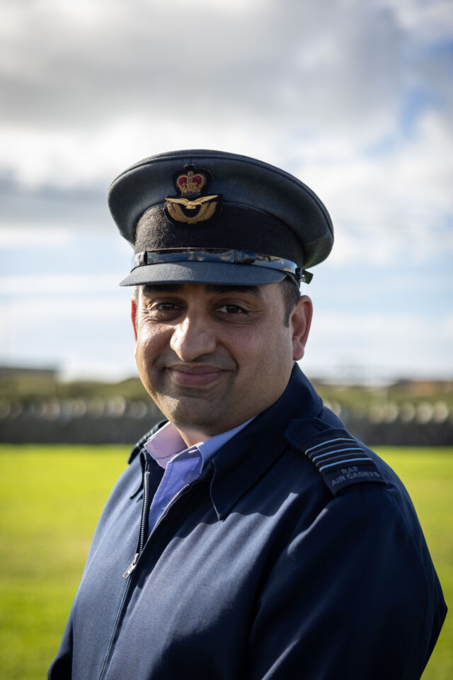 A male RAF Air Cadet in uniform and service cap stands outdoors.